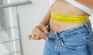 žena u trapericama mjesri struk krojačkim metrom