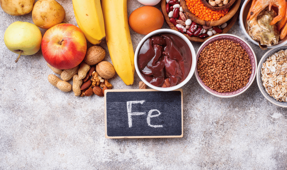Selekcija namirnica koje obiluju željezom i znak za željezo na sivoj podlozi