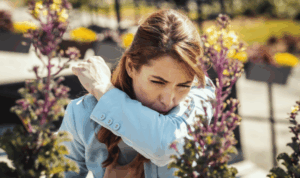 ŽEna u plavo sakou na otvorenom kiše isred cvijeća