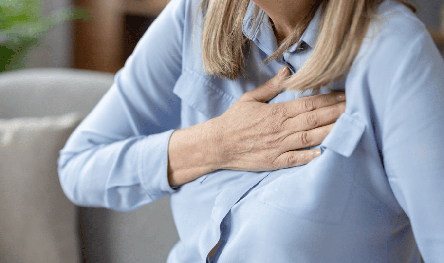 žena se drži za prsa, ima simptome GERB-a ili žgaravice