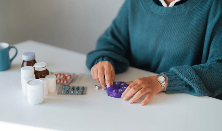 žena raspoređuje tablete u dispenzer za lijekove