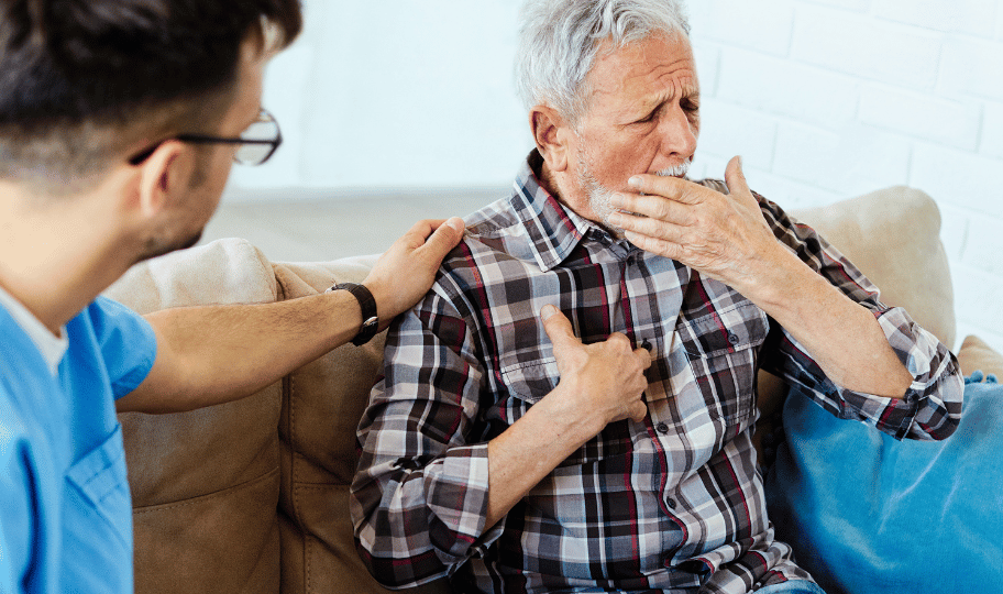 stariji muškarac kašlje, a zdravstveni djelatnik mu pomaže