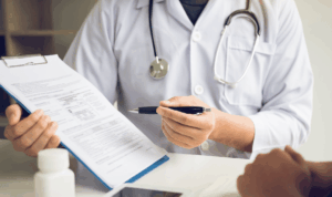 Zdravstveni djelatnik pojašnjava nalaze pacijentu za stolom