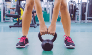 žena u teretani vježba s girjom