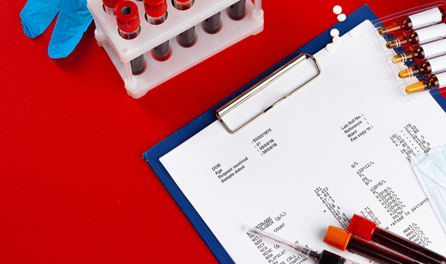 Laboratorijski nalaz i ampule krvi na crvenoj podlozi