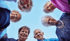 grupa prijatelja starije dobi gleda u kameru koja ih snima odozdo