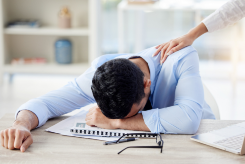 umorni muškarac spava na poslu za radnim stolom