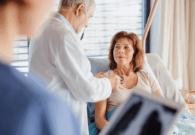 liječnica slulša srce žene u menopauzi koja leži u bolničkom krevetu