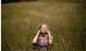 žena u menopauzi sjedi u polju i meditira