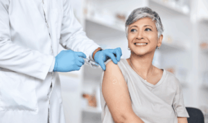 zdravstveni radnik cijepi ženu srednjih godina