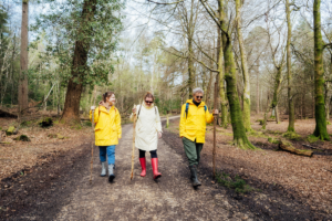 Tri žene u kabanicama šeću šumom