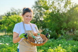 sretna žena se vrća iz vrta s češnjakom koji je sama uzgojila