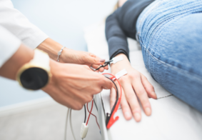 liječnikca izvodi emng na pacijentu koji leži