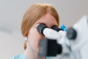 liječnica gleda kroz mikroskop