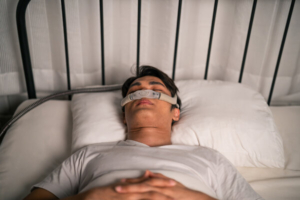 muškarac spava s maskom za apneju