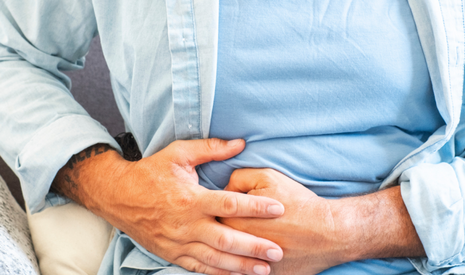 krupni kadar muškarca koji se drži za desnu stranu trbuha