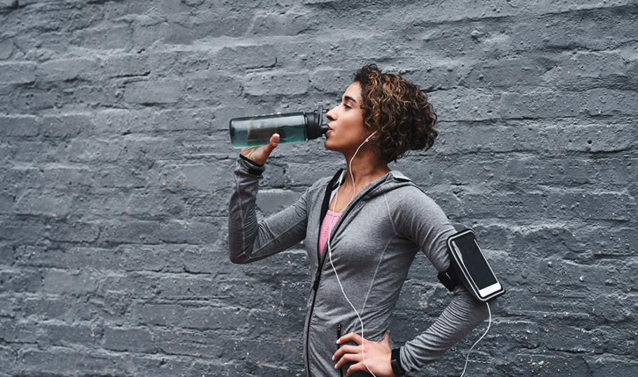 žena pije napitak s elektrolitima nakon treninga