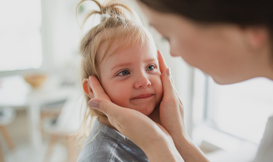 majka drži dijete za lice i pregledava ga u potrazi za simptomima impetiga