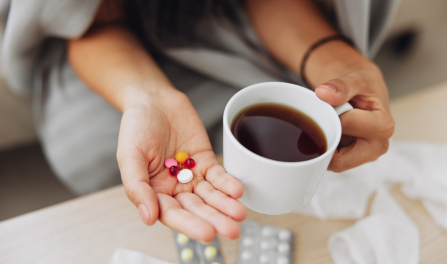 krupni kadar ženskih ruku koje drže šalicu kave i razne tablete