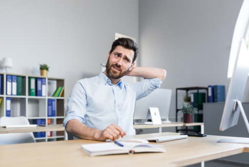 dekoncentrirani, zbunjeni muškarac sjedi za radnim stolom