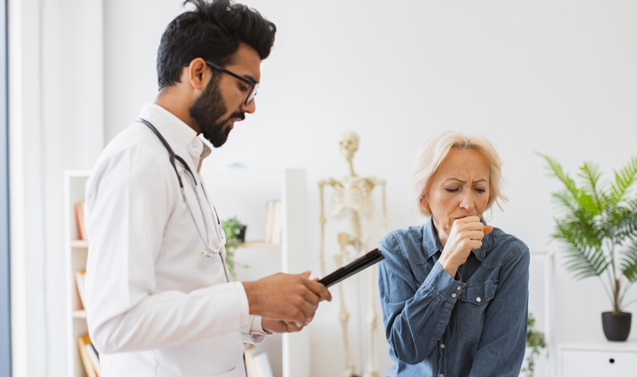 liječnik specijalist u ordinaciji sa starijom pacijenticom koja kašlje, kopb