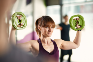 snažna mlada žena u teretani vježba s utezima