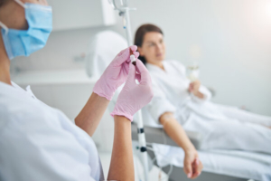 medicinska sestra daje kemoterapiju pacijentici u bolničkom krevetu