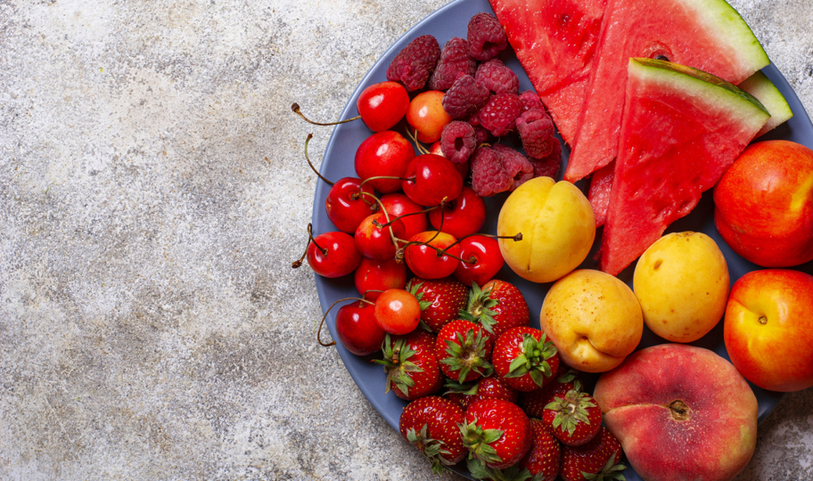 ljetno voće na tanjuru na sivoj podlozi