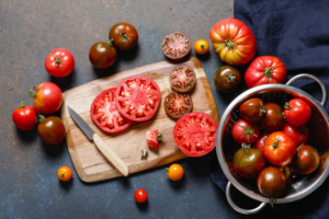 razne vrste rajčica u zdjeli i narezane na dasci