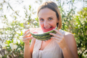 portret vesele žene koja jede lubenicu