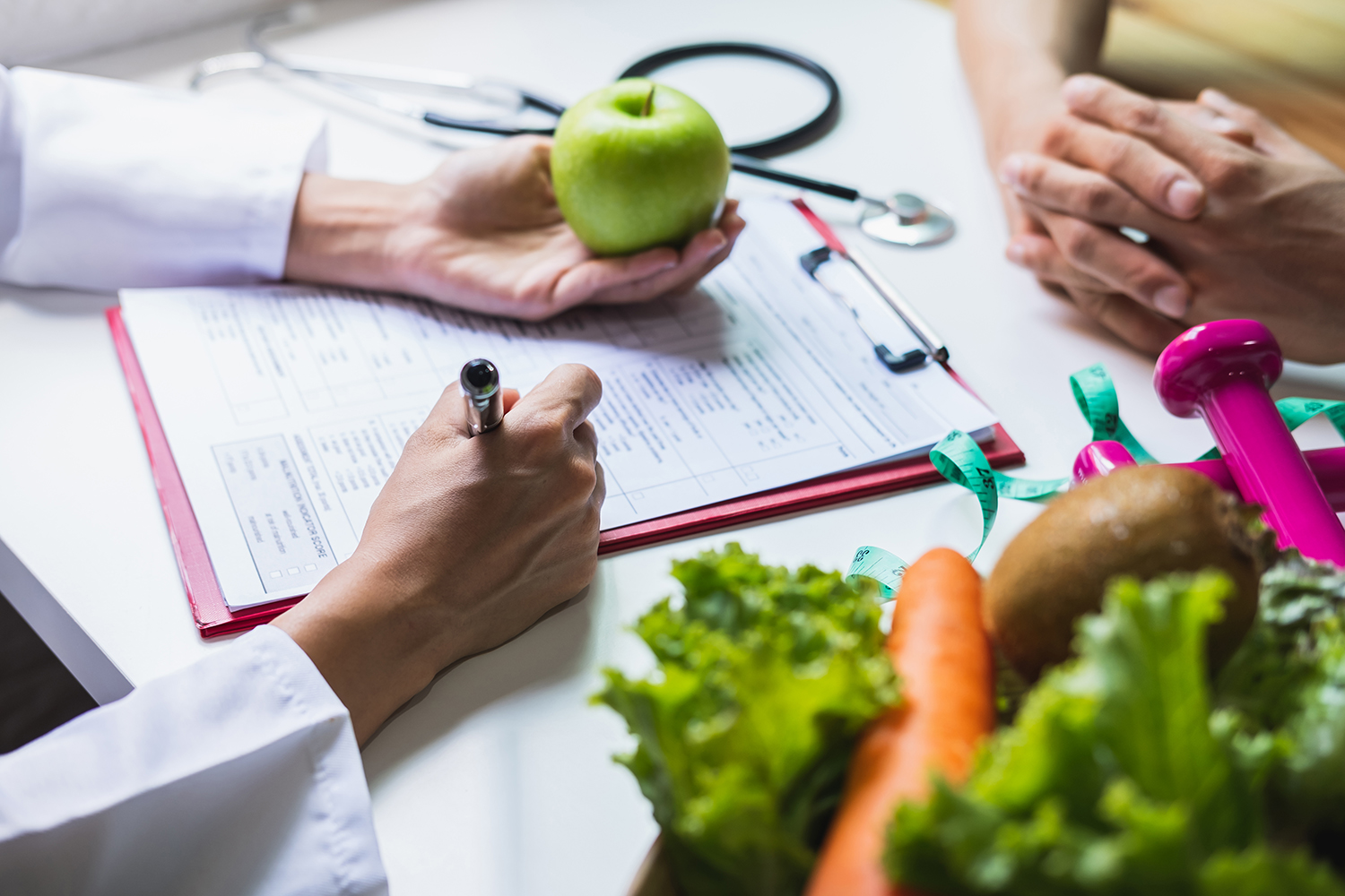 nutricionistica s pacijentom razgovara o metabolizmu i zapisuje podatke o pacijentu
