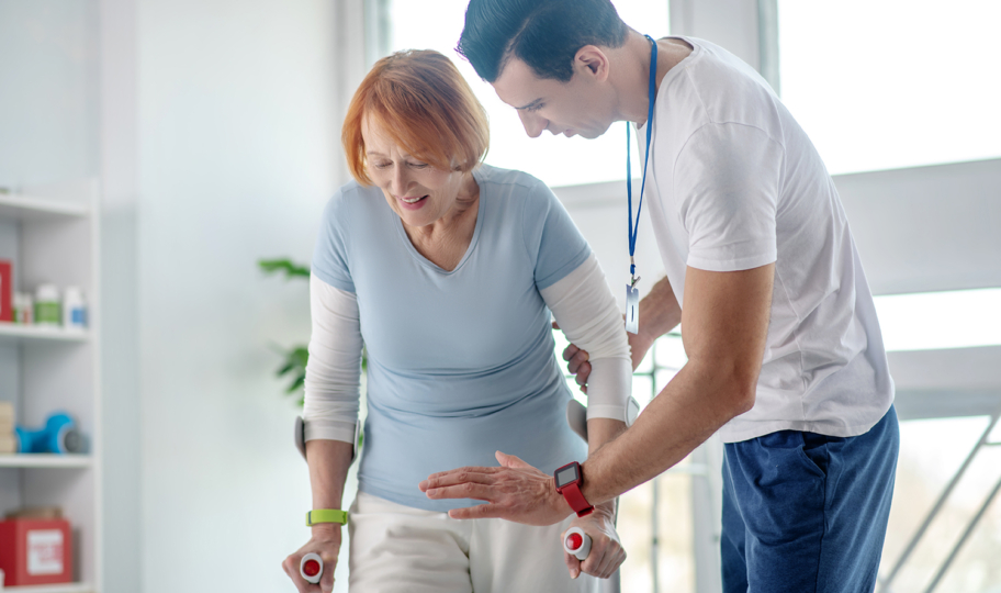 starija žena na fizioterapiji pokušava hodati, oporavak nakon moždanog udara