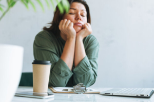 umorna žena za stolom