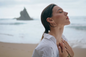 portret žene na plaži koja se opušta udišući svježi morski zrak