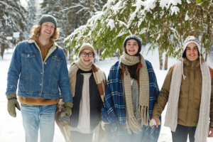 četiri mlada, vesela prijatelja zajedno u šetnji po sijegu