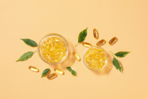 kapsule omega 3 masnih kiselina u staklenim posudicama na žutoj podlozi