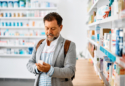 muškarac u ljekarni čita uputu o lijeku