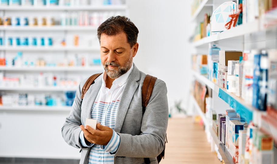 muškarac u ljekarni čita uputu o lijeku