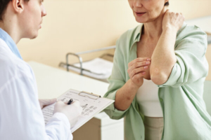 žena na pregledu kod dermatologa, pokazuje na simptome na laktu