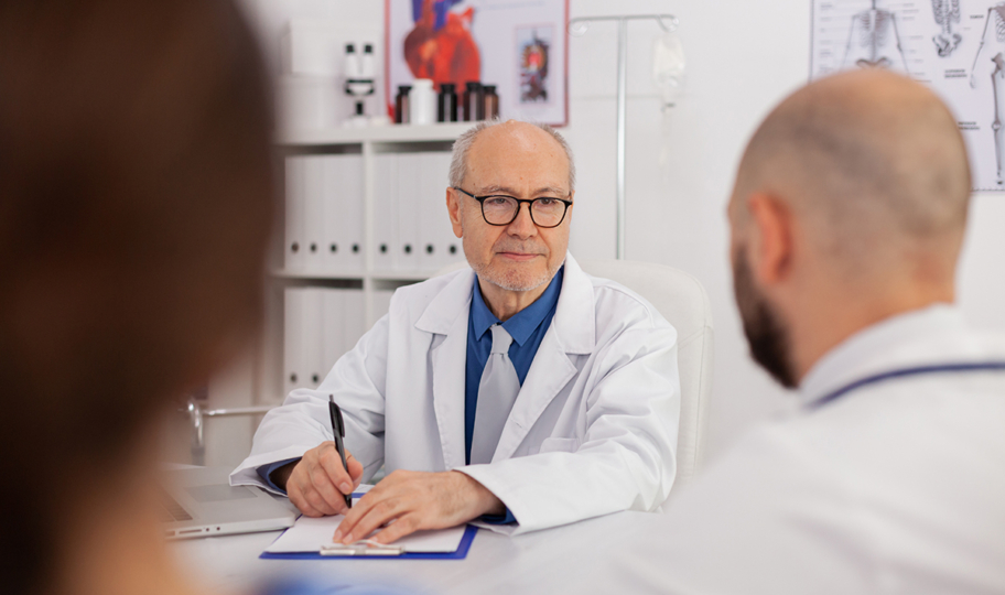 liječnik razgovara s kolegama za stolom u ordinaciji