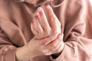 žena se držui za bolni zglob ruke