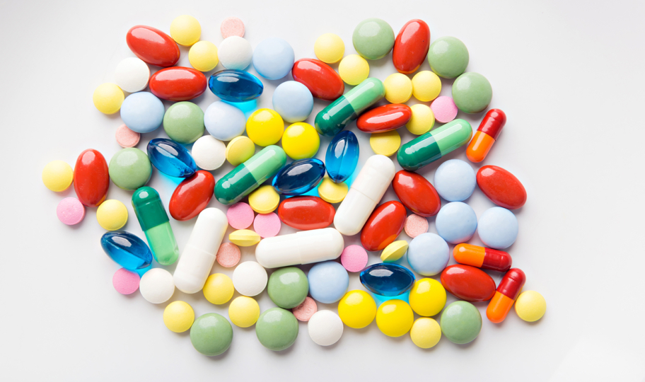 hrpa šarenih tableta na bijeloj kamenoj podlozi