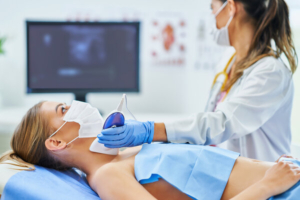 liečnica izovdi uzv štitnjače na pacijentici koja leži