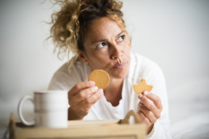 portret žene koja jede keks i razmišlja da i da pojede i drugi