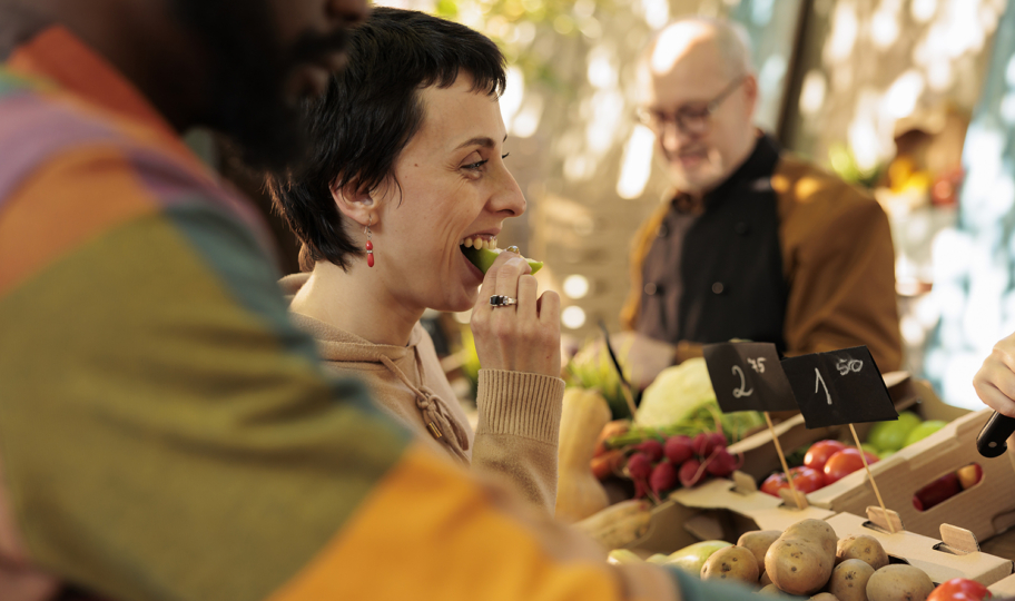 portret žene koja degutira namirnice na tržnici