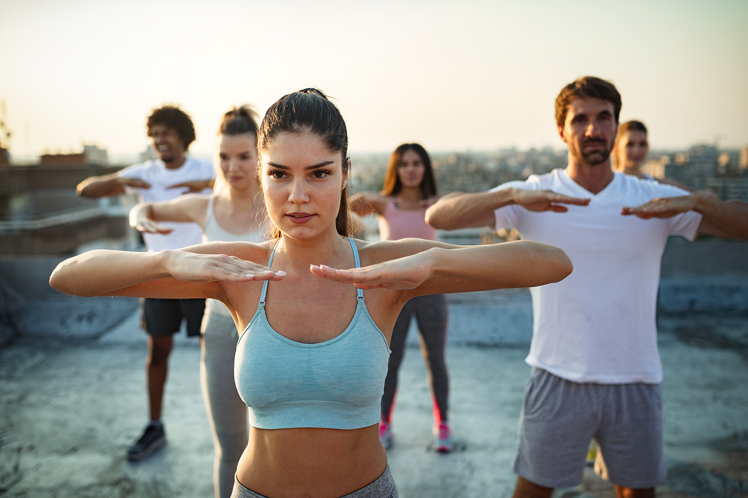 grupa mladih, fit ljudi vježba na krovu zgrade