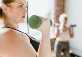 portret mlade žene koja vježba s bučicama