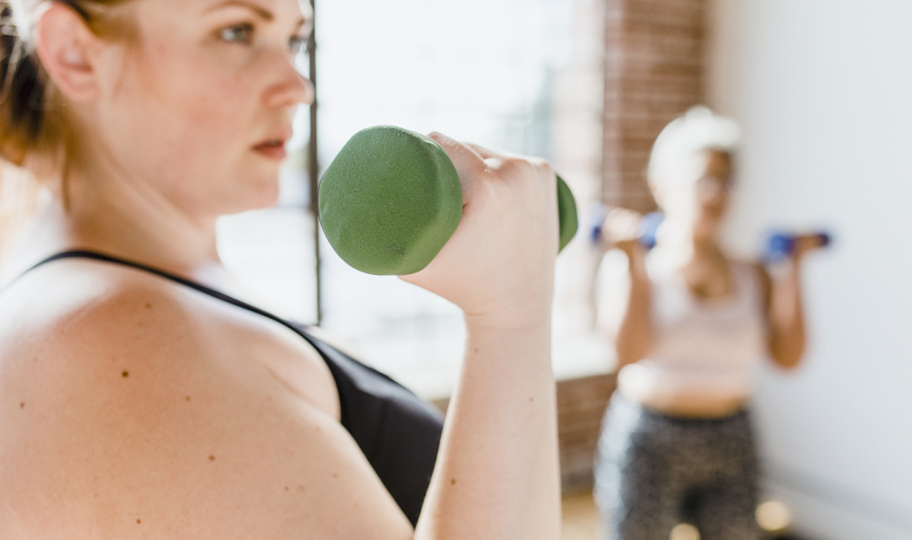 portret mlade žene koja vježba s bučicama