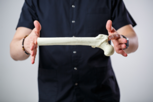 muškarac u crnoj košulji kratkih rukava drži veliku kost