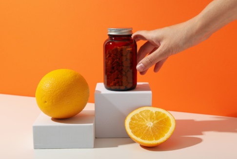 vitamin c u bočici u obliku tableta, naranče